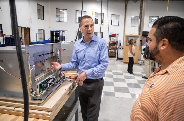 Kevin Nolan talks about the oven's technology with a guest at the event 