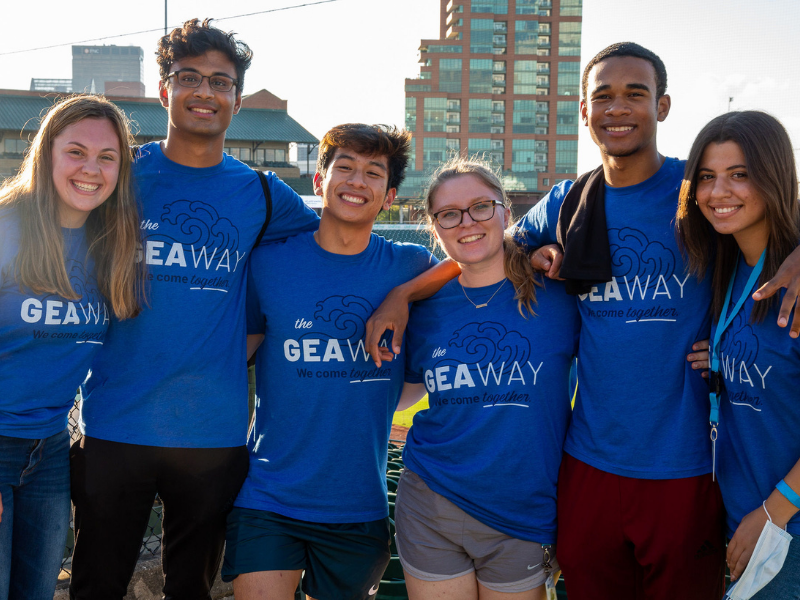 group of students smile together wearing GEA Way shirts