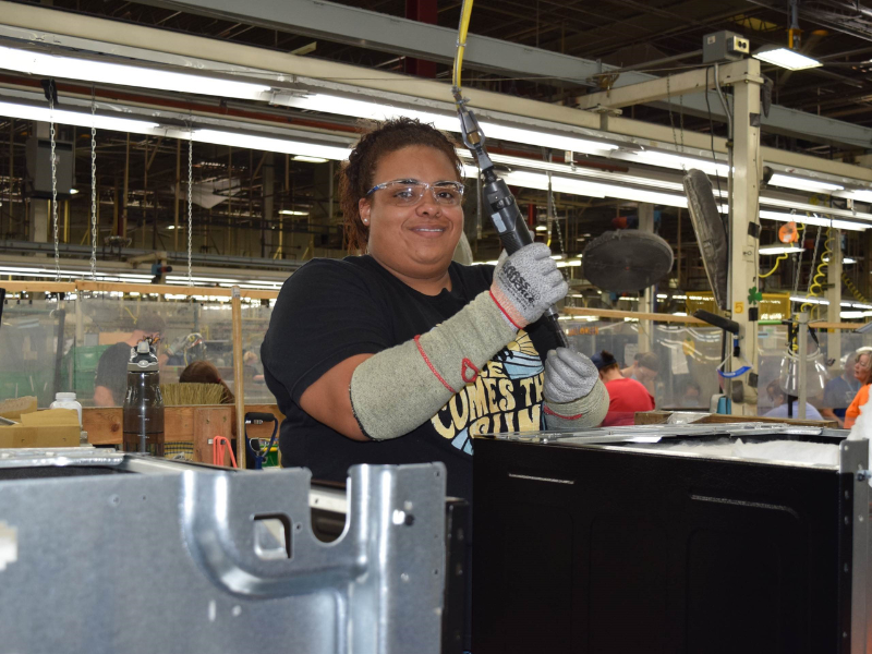 Female Roper employee smiles for a photo while working on the production line